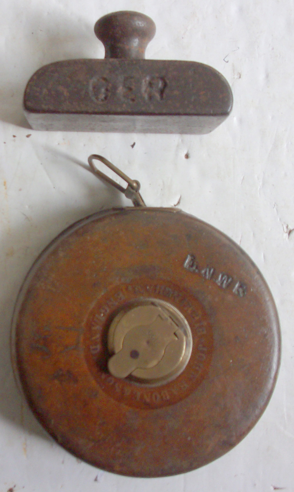 L&NWR 66ft Tape, in excellent condition, sound full working order, measures in ft and inches and on reverse links. Accompanied with GER cast iron paperweight.